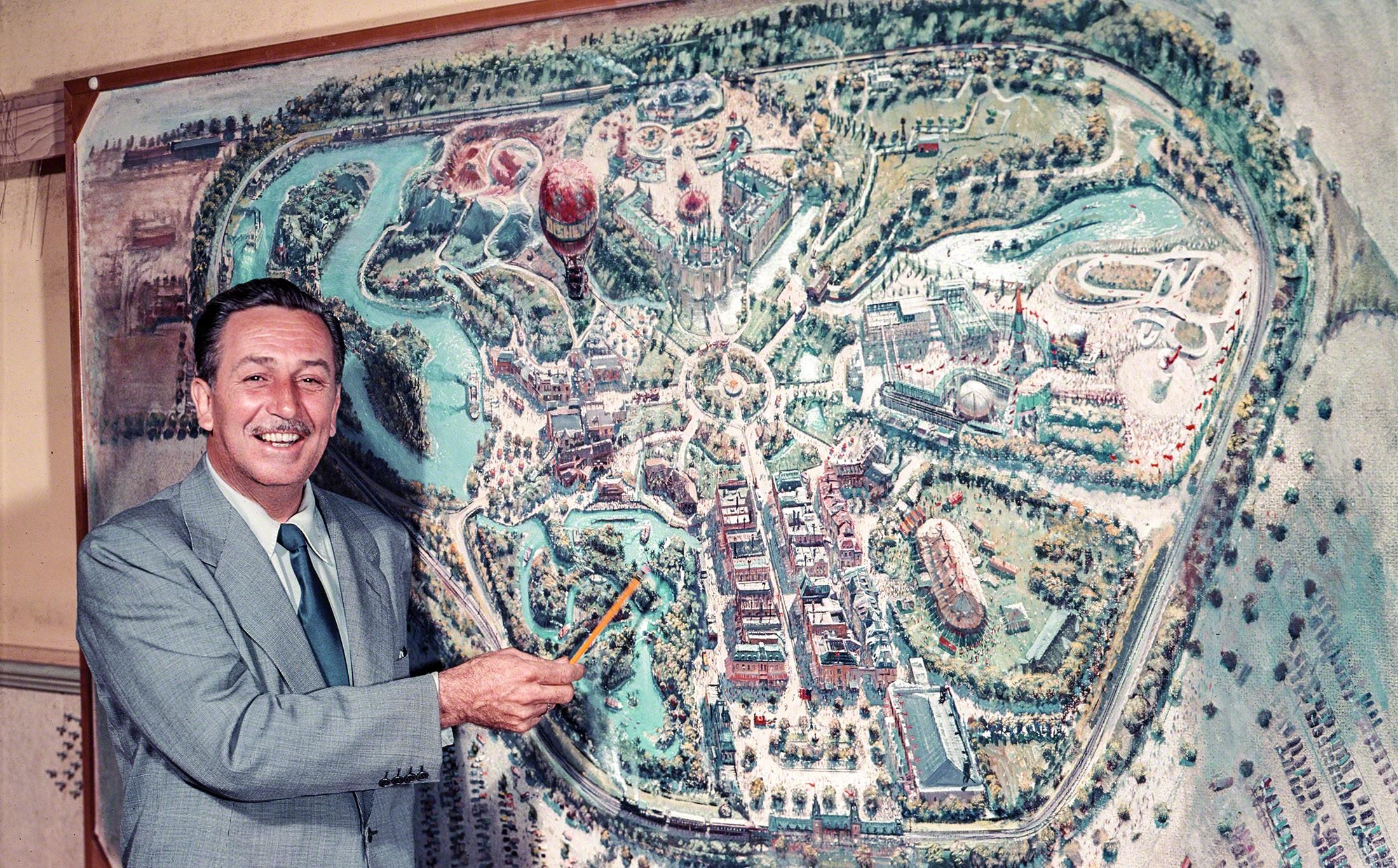 Walt Disney pointing to a plan for Disneyland, under construction in Anaheim. July 1954 Los Angeles.jpg
