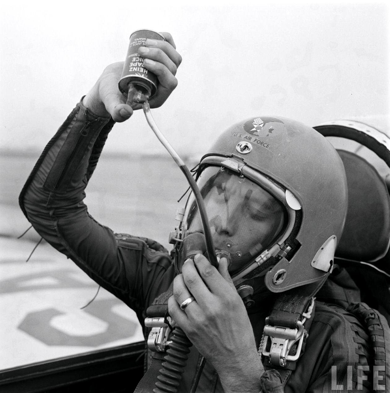 An Air Force test pilot drinking grape juice while wearing an MA-2 High Altitude Flight Helmet, 1954.jpg