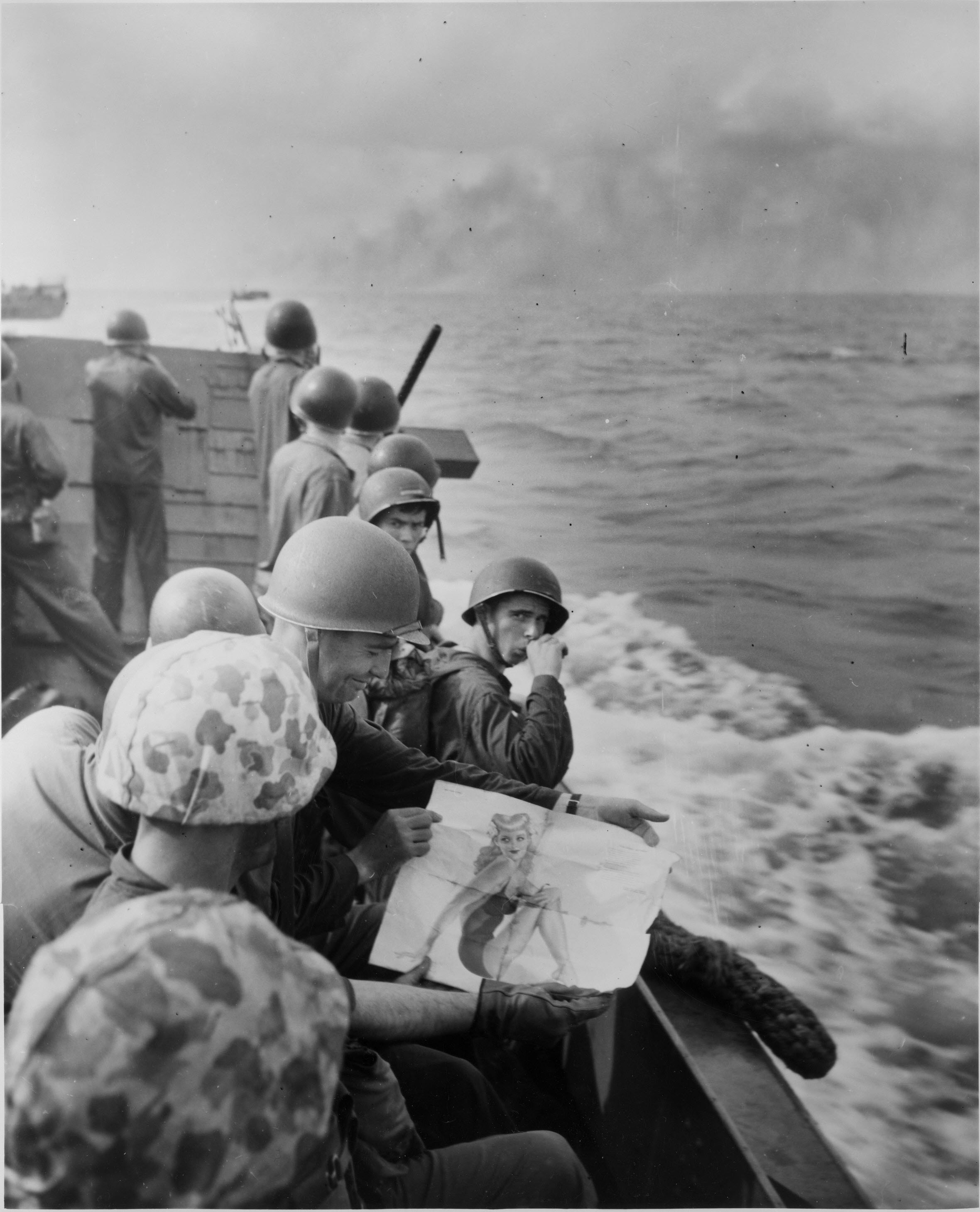 Marines on a landing barge approaching enemy-held island of Tarawa burning in the background, 1943.jpg