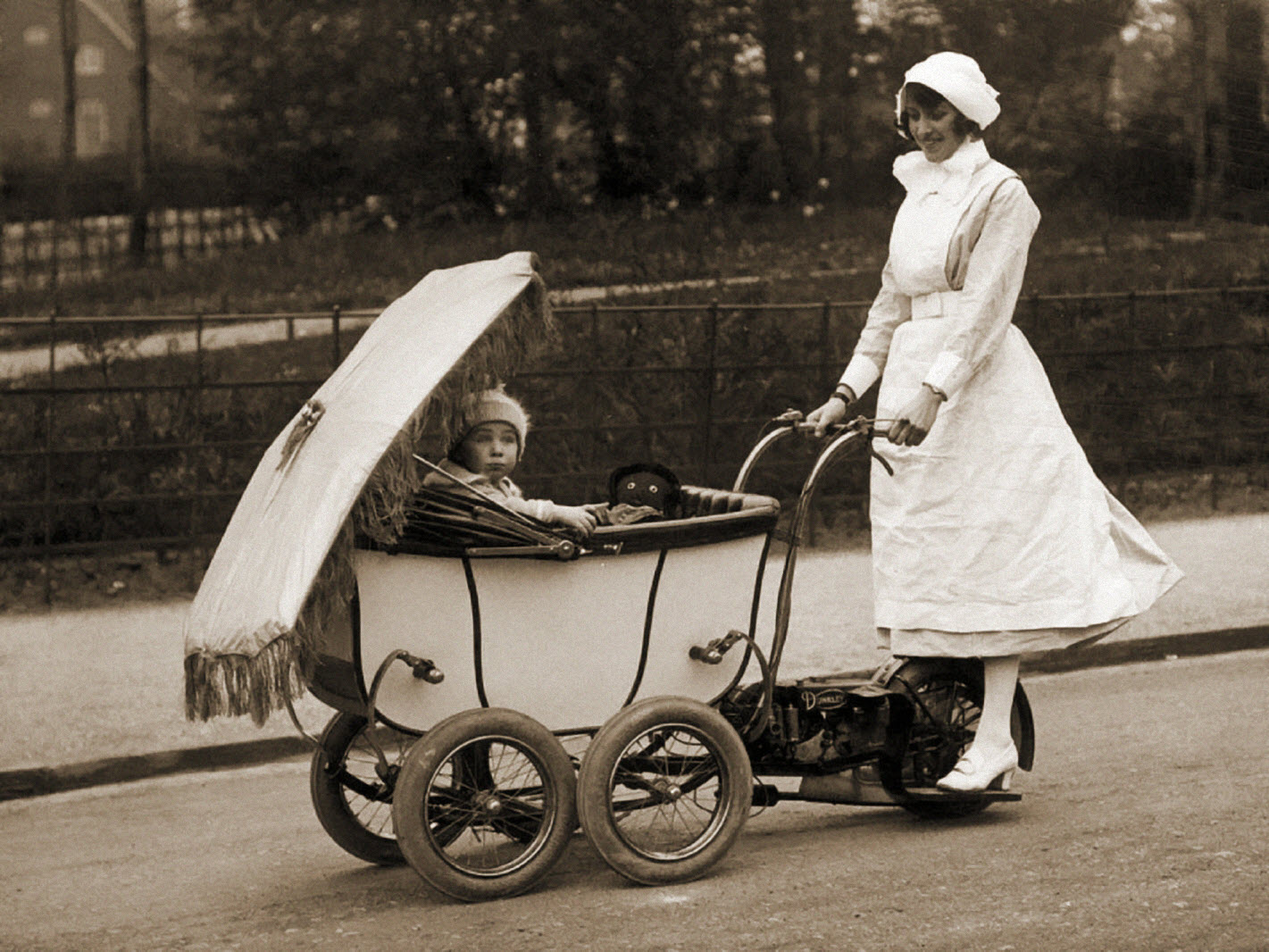 Nurse driving a motorized baby pram, 1922.jpg