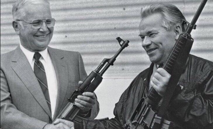 Mikhail Kalashnikov and Eugene Stoner hold each other’s invention. May 1990.jpg