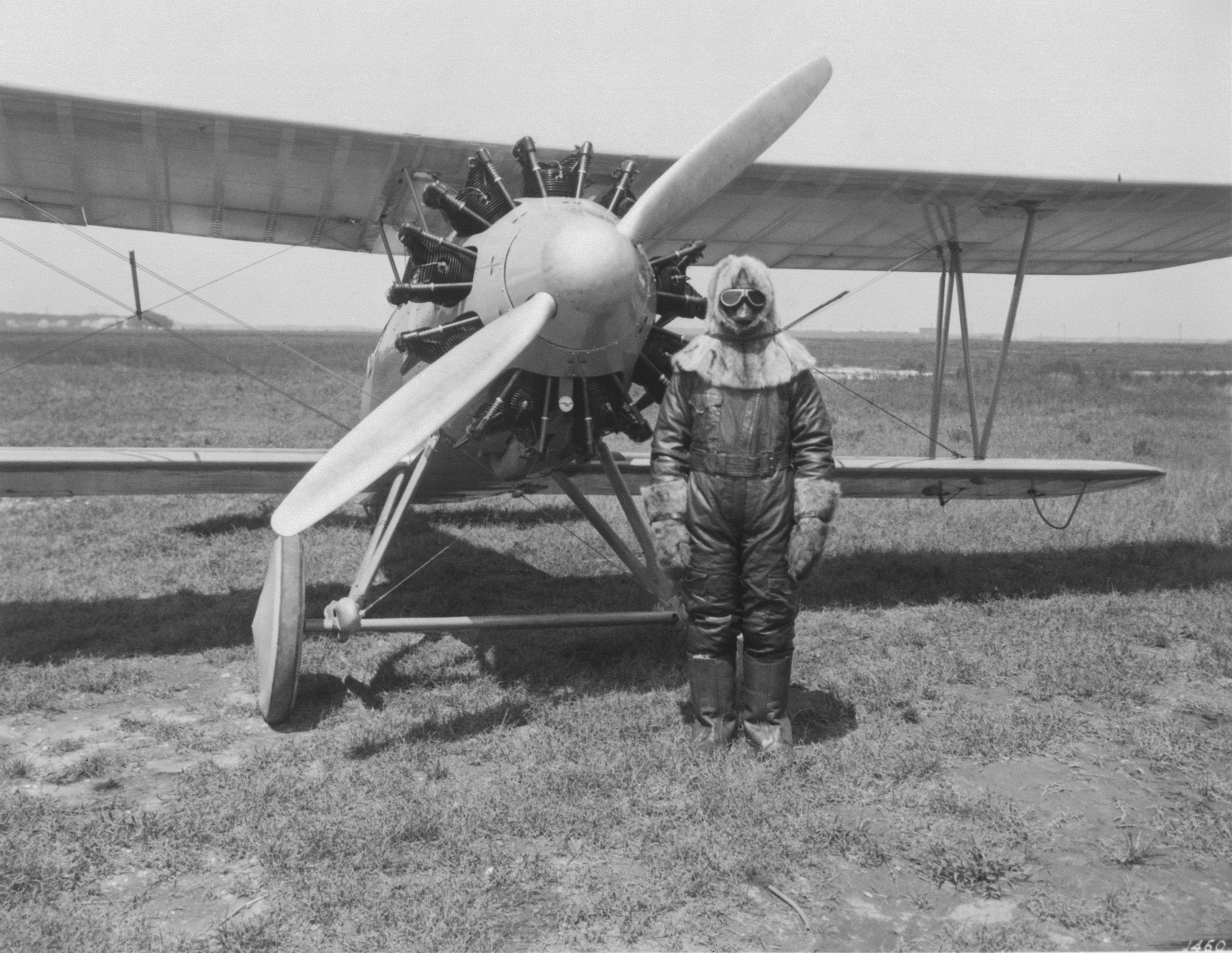 An aviator equipped with high altitude flying gear poses next to a Wright Apache on June 10, 1929.jpg