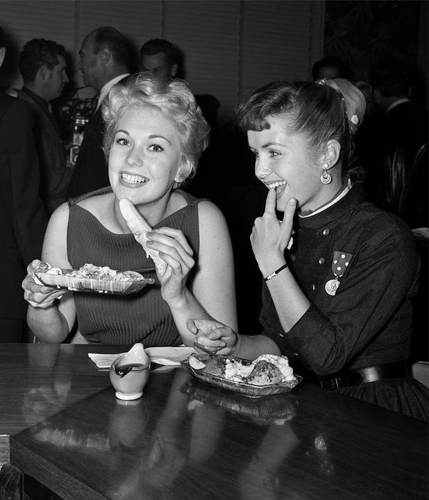 Kim Novak and Debbie Reynolds enjoying a banana at Schwabs Pharmacy in Hollywood, 1954.jpg
