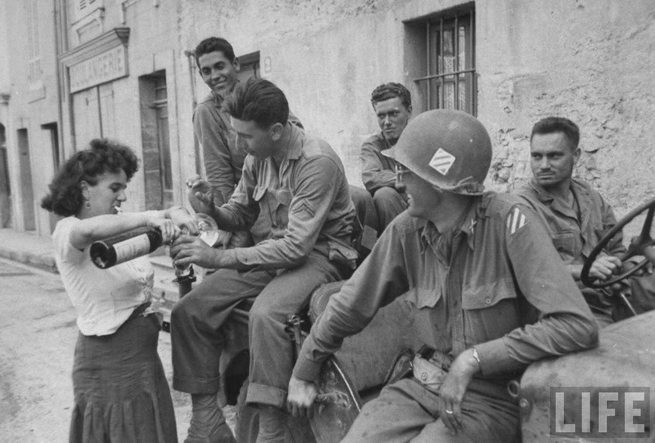 French woman pouring wine for appreciative American soldiers after liberation from the Germans. Brignoles, France 1944.jpg