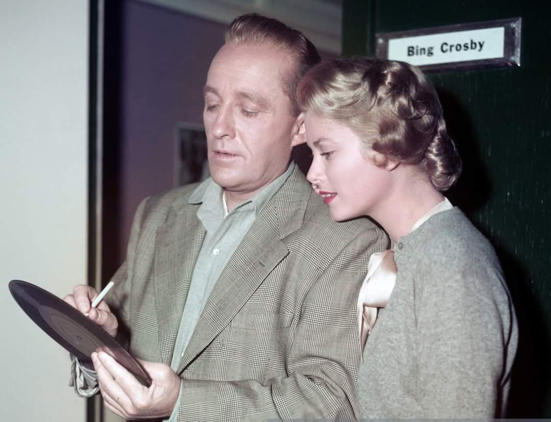 Bing Crosby autographs one of his records for co-star, and future Princess of Monaco, Grace Kelly, circa 1954.jpg