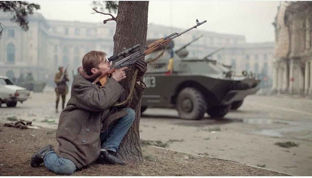 An anti-communist Romanian civilian returning fire upon pro-Ceausescu soldiers. Ca 24 of december 1989.jpg