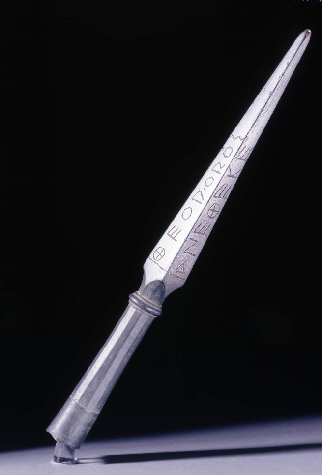 Greek Bronze Spearhead with an inscription reading Theodoros dedicated [me] to [Zeus] the King.Recovered in Olympia, Greece, dated ca. 500 BC, and housed at the British Museum.png