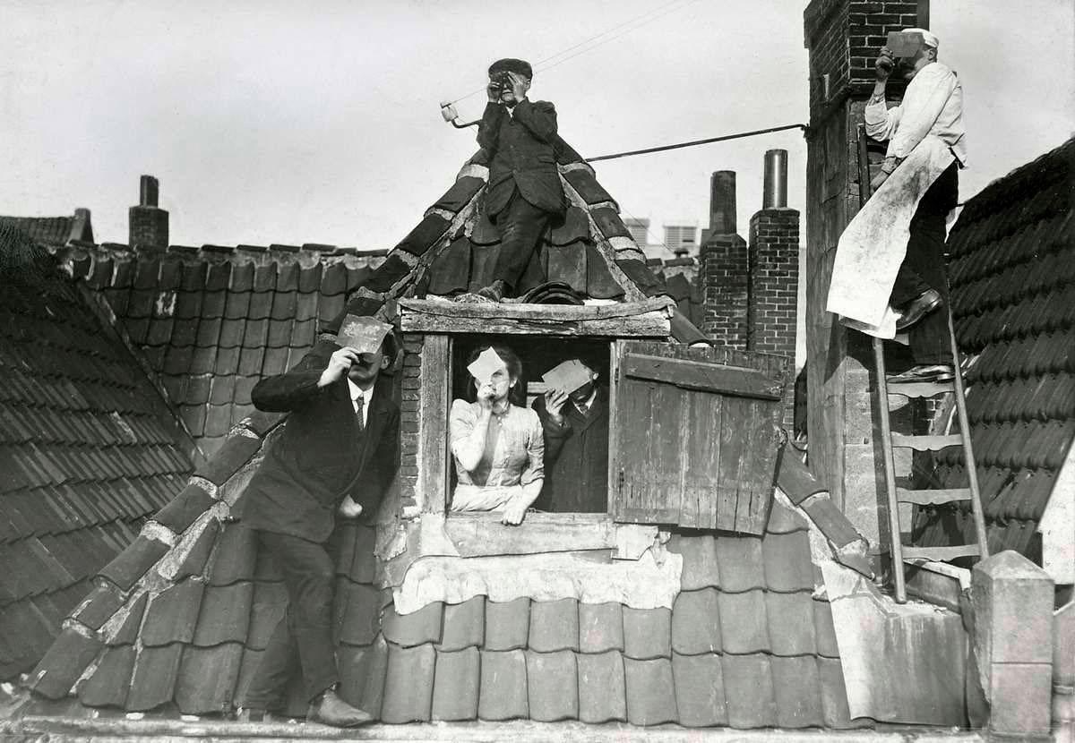 A group of people in Rotterdam, Netherlands watching a Solar Eclipse from their rooftop (1912).jpg