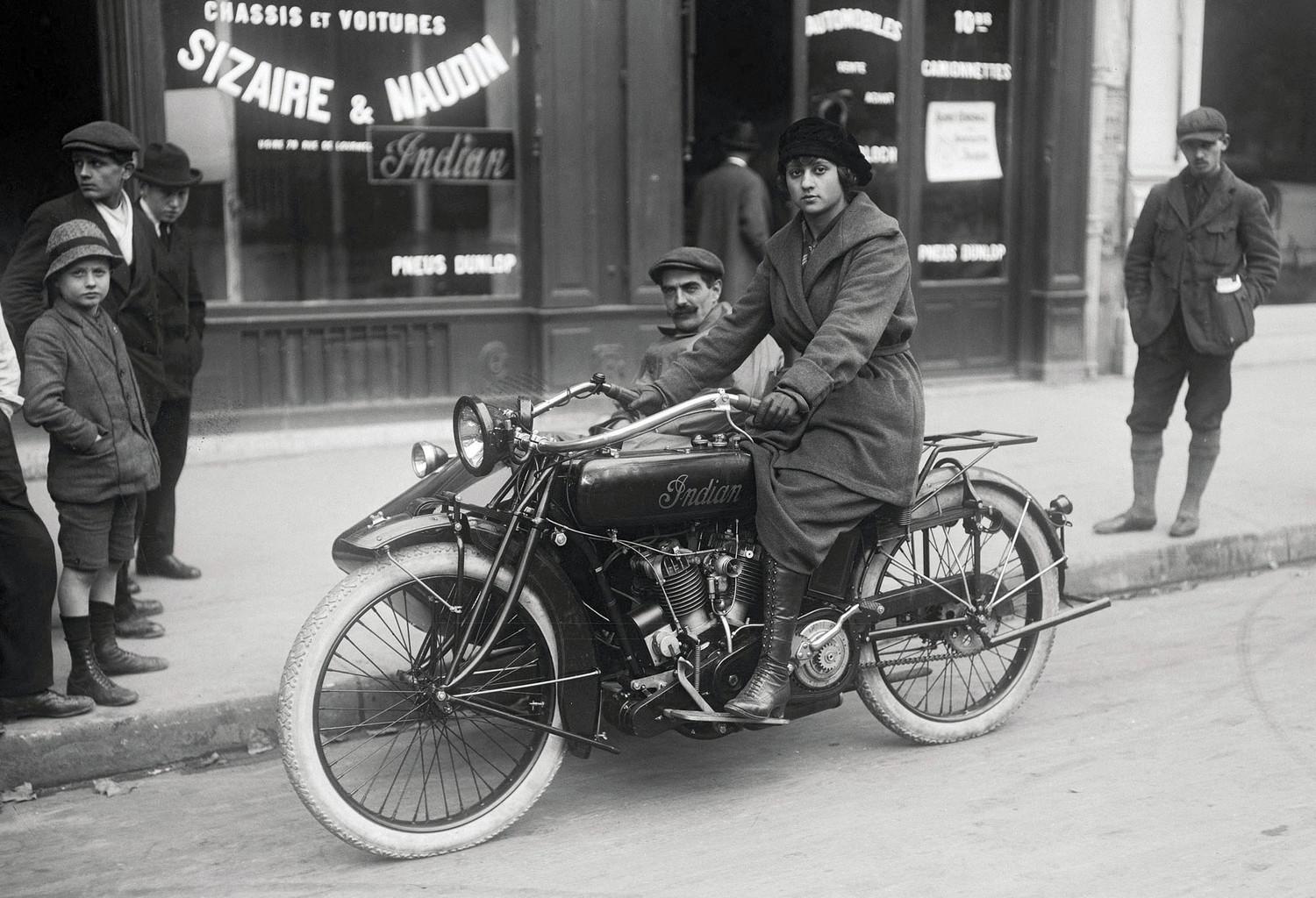 A woman poses on an Indian motorcycle with a sidecar on a street in Paris, France, in 1919.jpg