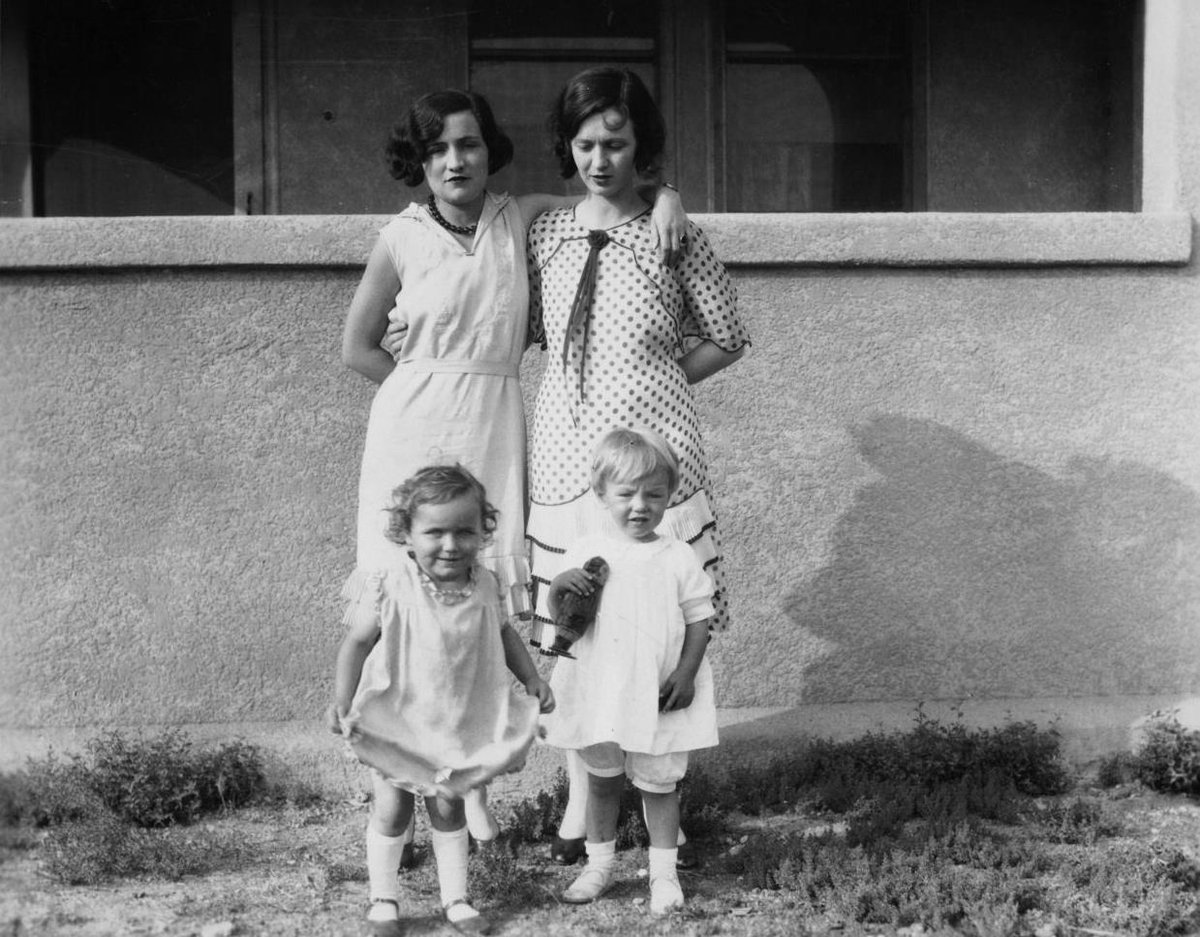Three year old Marilyn Monroe with her mother (both standing on the right). Unknown location, 1929.jpg
