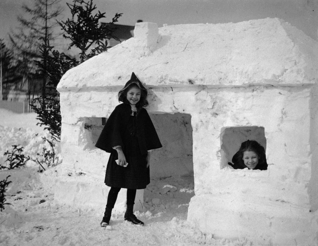 Two girls stand outside a snow fort, 1910. by Jeanette Bernard.jpg