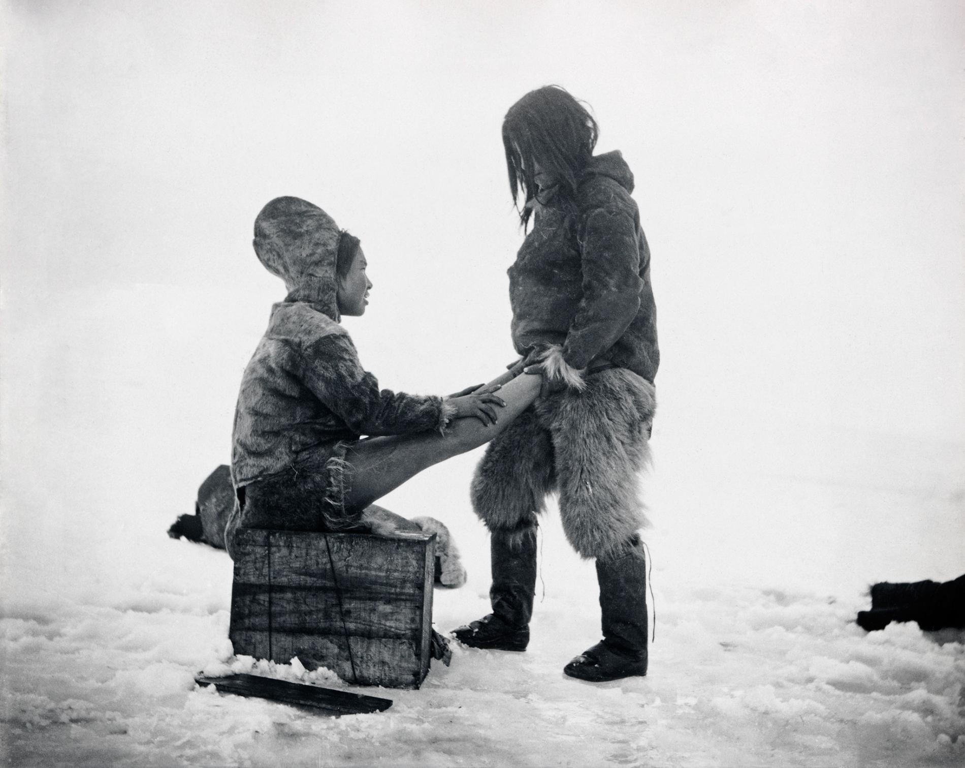 An Inuit man warms up his wife’s feet in Greenland, c. 1898-1902.jpg