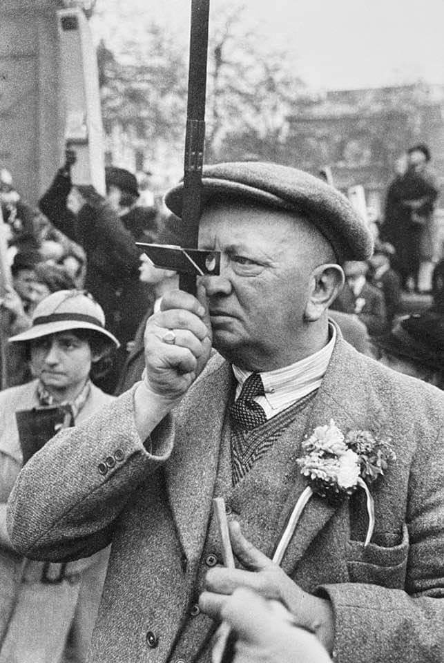 Crowds look to get a view of the procession using a periscope during the Coronation of King George VI. (Circa 1937).jpg