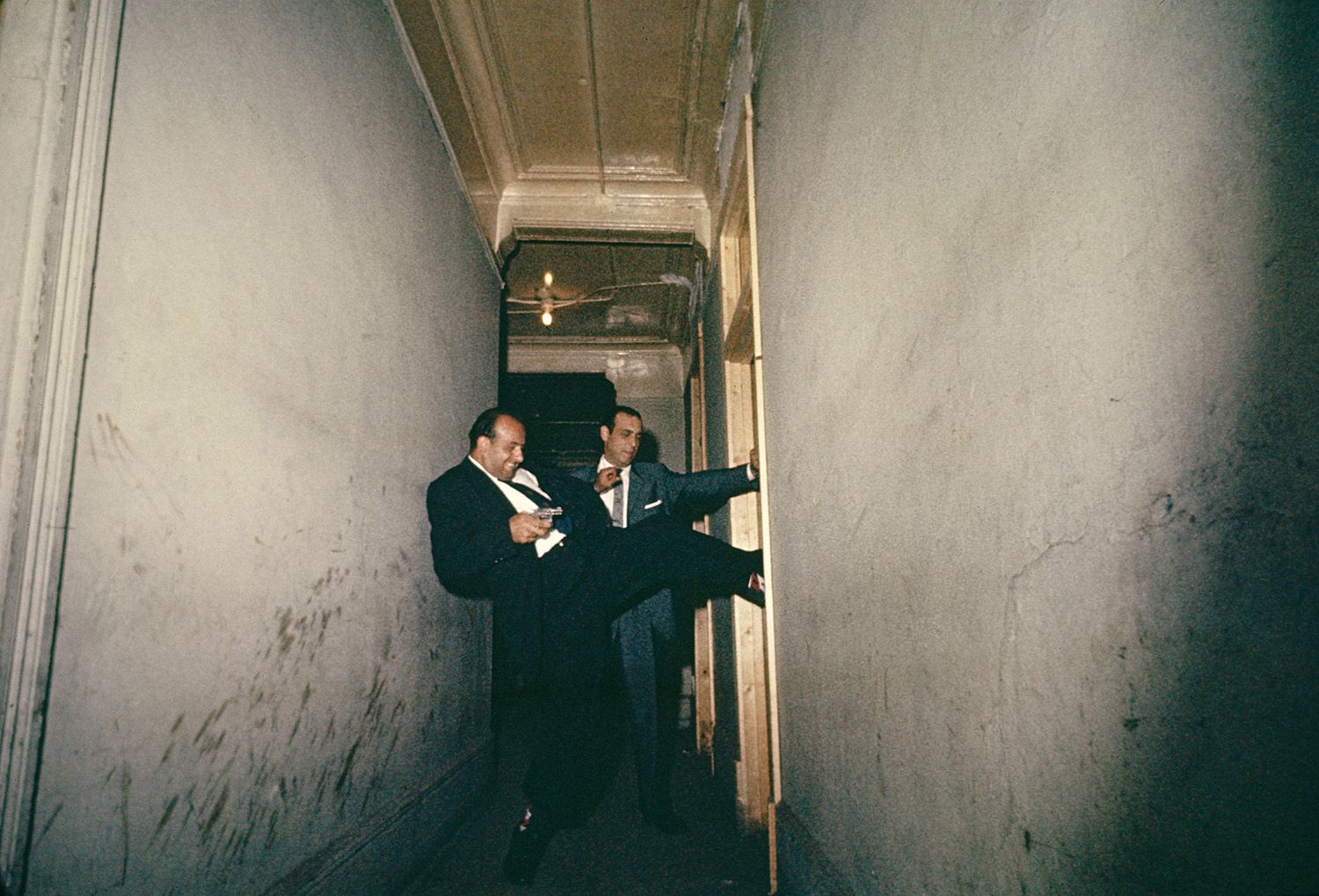 A pair of detectives break down a door in Chicago, 1957.jpg