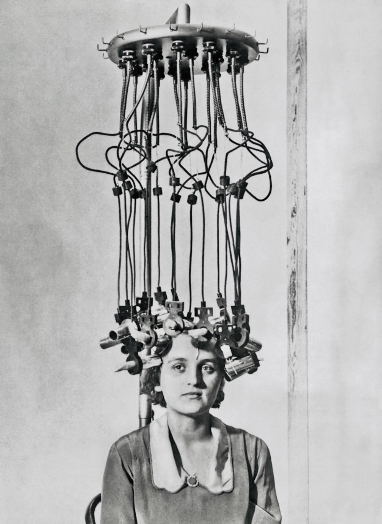 Women sat under a permanent hair waves machine for about 10 hours to achieve wavy hair. Often, the machine would malfunction.jpg