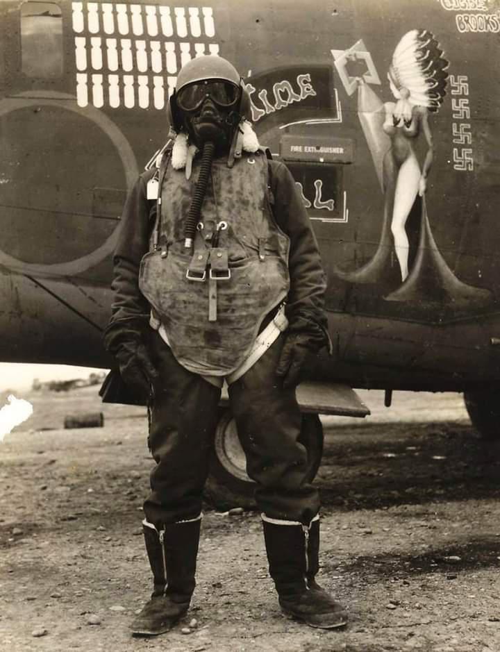An airgunner stands before his B-24 bomber wearing what it took to survive at 25,000ft altitude, 1944.jpg