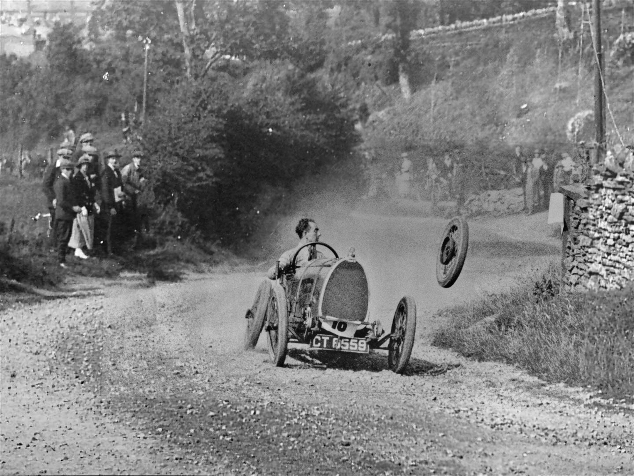 Raymond Mays keeping his old school cool after losing a wheel at the Caerphilly Mountain Hill climb race in Cardiff, Wales, 1924.png