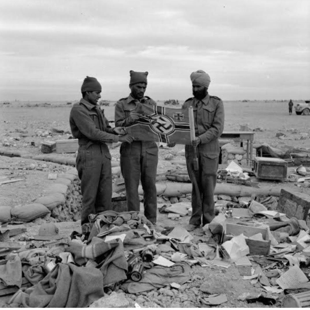 Indian soldiers holding a Nazi Flag which they captured at Libyan Omar c.1941.jpg