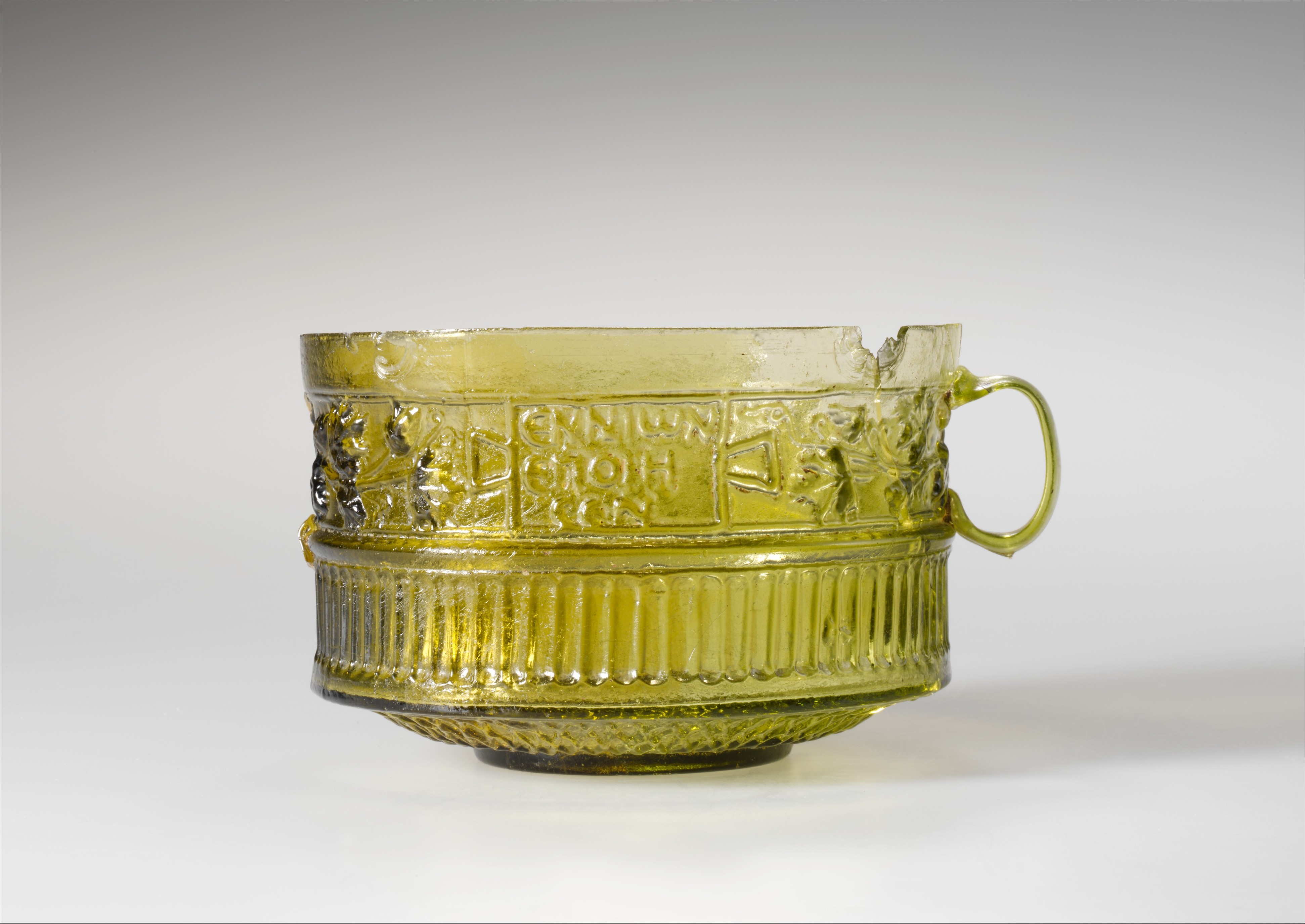 Ancient Roman era yellow glass cup with Greek inscription made by an artisan named Ennion, c. 1st century CE.jpg