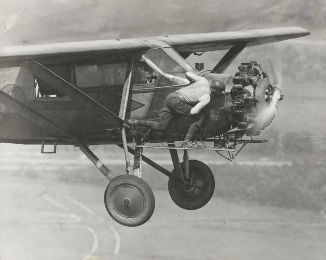 Hunter Brothers doing some mid-air mechanical checks during their 23-day-long continuous flight in 1930. During the flight, food and fuel were delivered to them periodically by another airplane.jpg