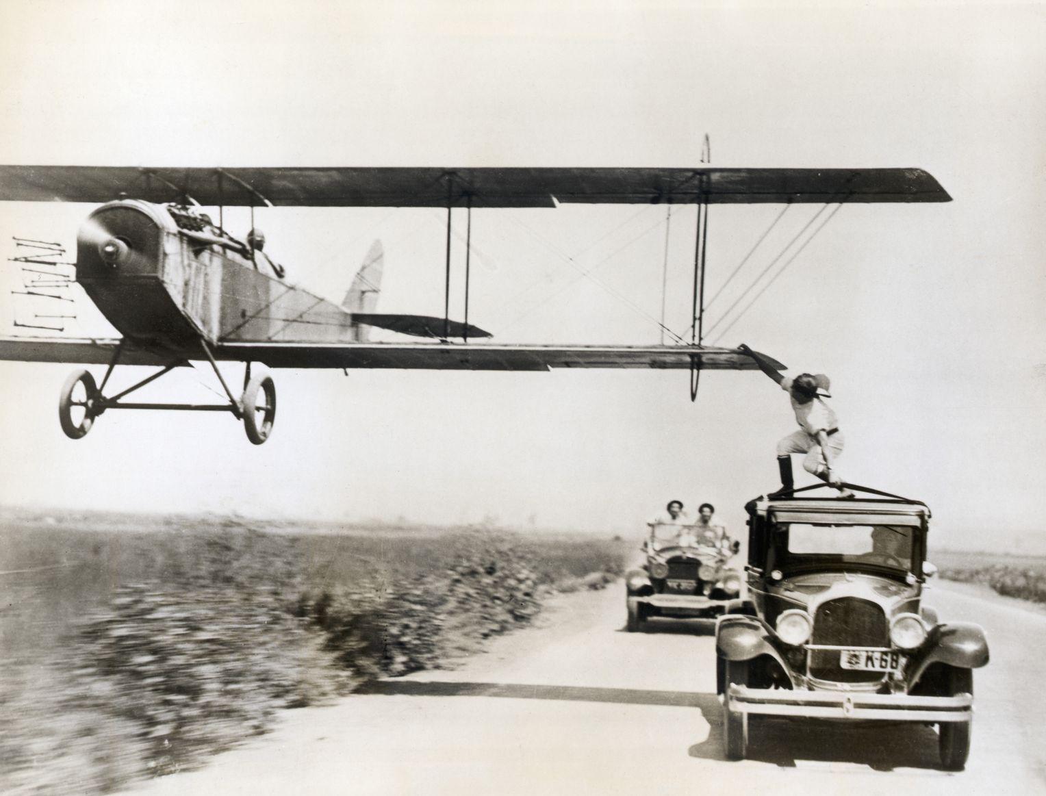 Al Wilson leaping onto an airplane from the top of an automobile traveling 80 miles an hour, 1927.jpg
