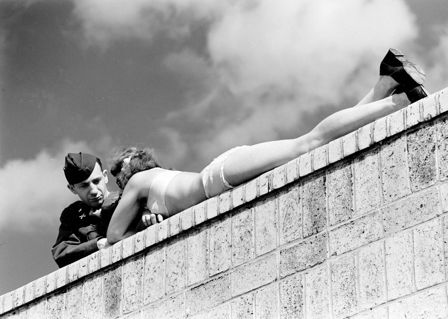 An American soldier chats with a sunbathing German girl in postwar Berlin, Germany, in 1945.jpg