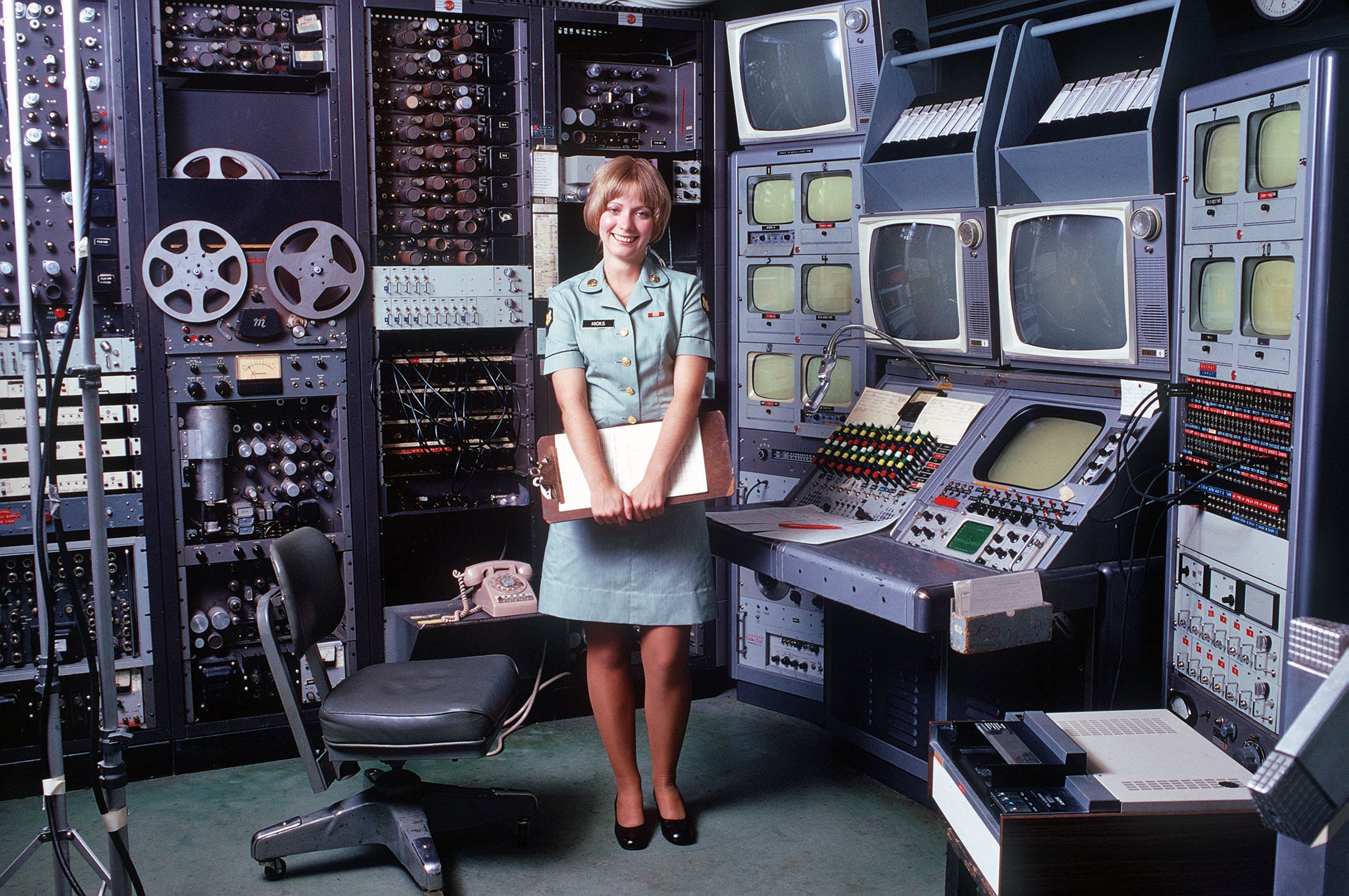 U.S. Army audiovisual technician stands at her videotape editing station, 1973.jpg