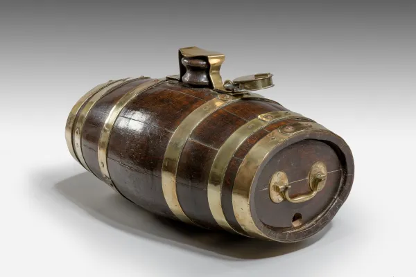 Royal Navy Rum barrel in dark oak with six brass bands, the top with a large wooden bung covered with a brass strap, securely kept in place with a large padlock, c. 1850.png