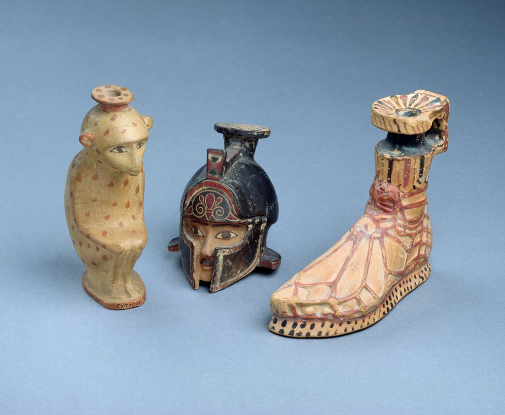 Three east Greek 'Plastic' perfume-pots in the form of a crouching monkey a warrior's helmet and a sandled foot, 7th century BC.jpg