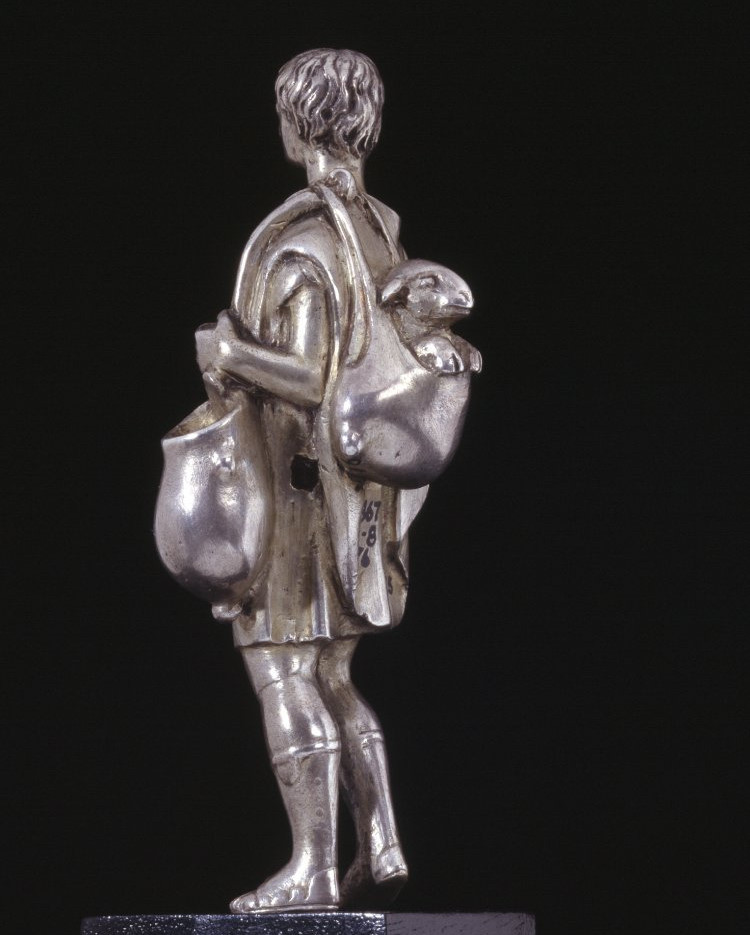 Silver statuette of a shepherd carrying a sheep in a skin bag slung over his shoulder. Roman, 1st century A.D.jpg