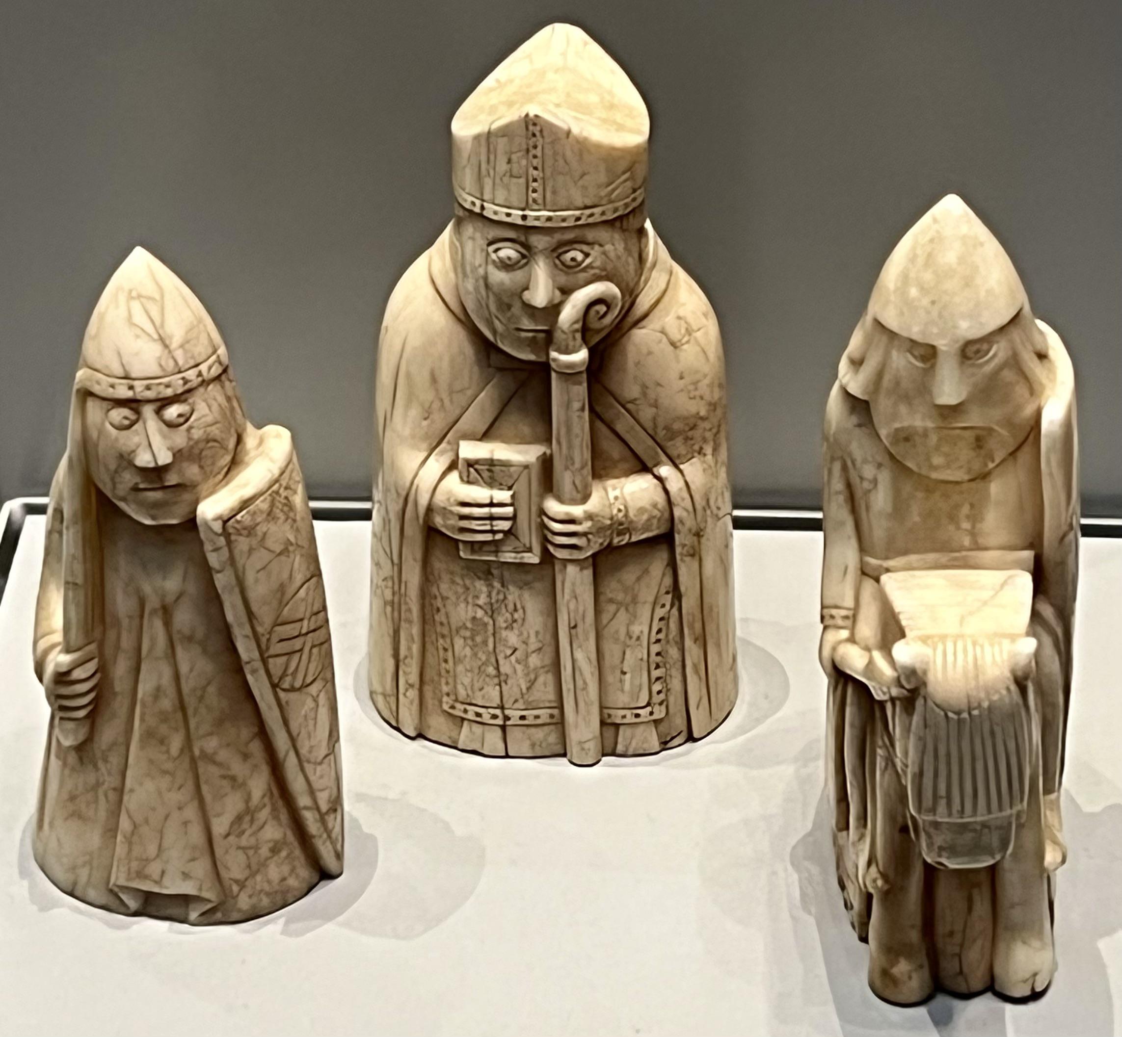 Three of the Lewis chessmen a group of distinctive 12th-century chess pieces, most of which are carved from walrus ivory. Discovered in 1831 on Lewis in the Outer Hebrides of Scotland.jpg