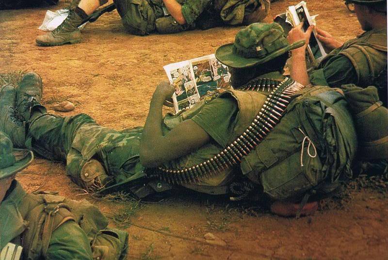 US troops of a long-range reconnaissance patrol in Vietnam, reading comic books in their downtime (1960s).jpg