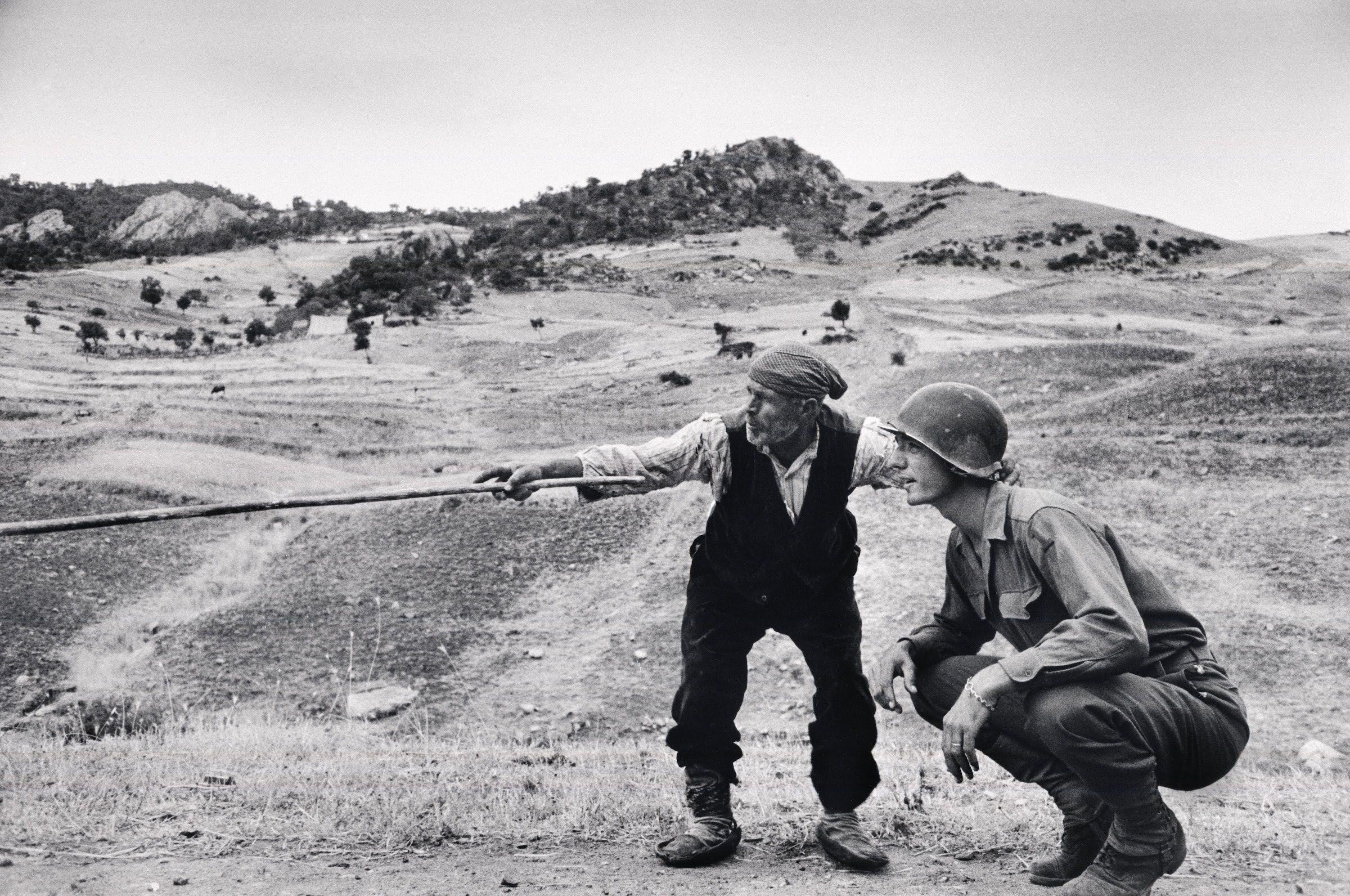 Sicilian peasant telling an American soldier which way the Germans were, August 1943.jpg
