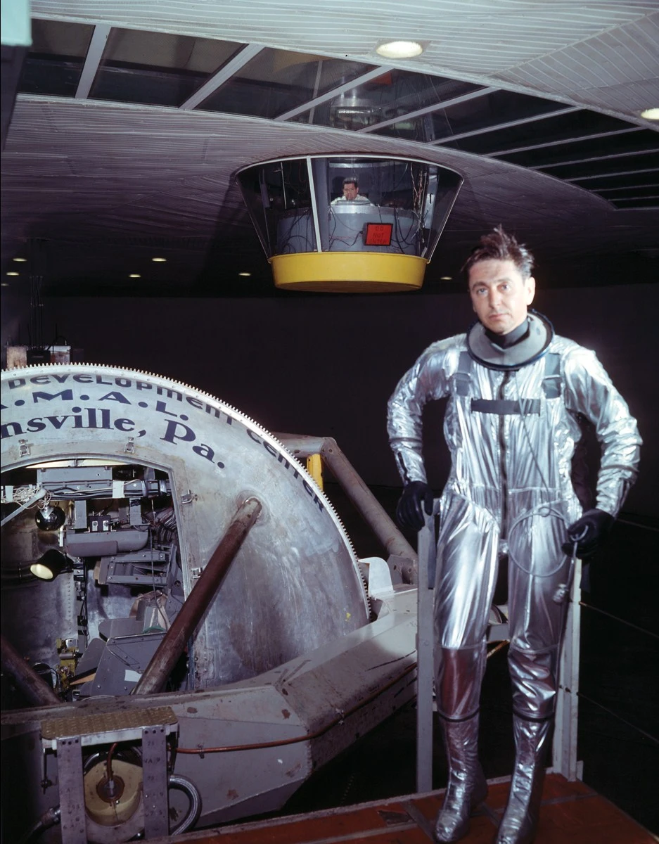 Test pilot Scott Crossfield models David Clark prototype of the future NAA X-15 pressure suit, the XMC-2. The photo was taken at the Aero Medical Laboratory on 14 October 1957.png