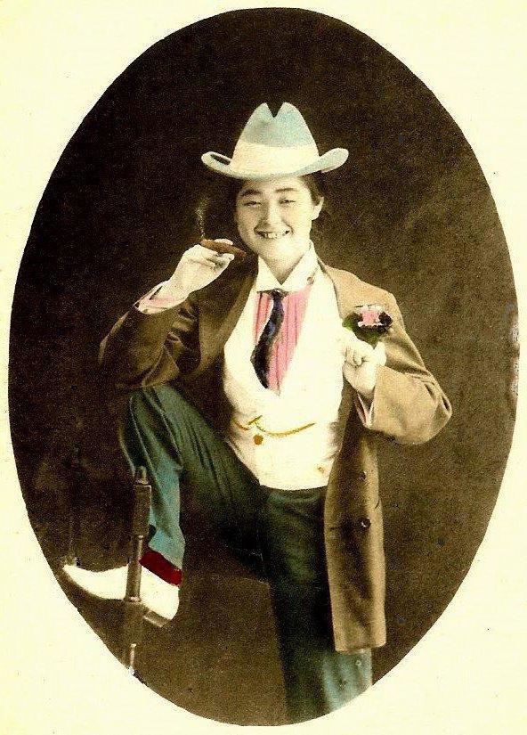 A Geisha dressed in male Western clothing, holding a cigar, late 1800s.jpg