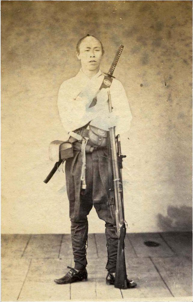 A late Edo samurai wears a Katana in a back carry configuration, while holding a musket. Circa 1860’s.jpg