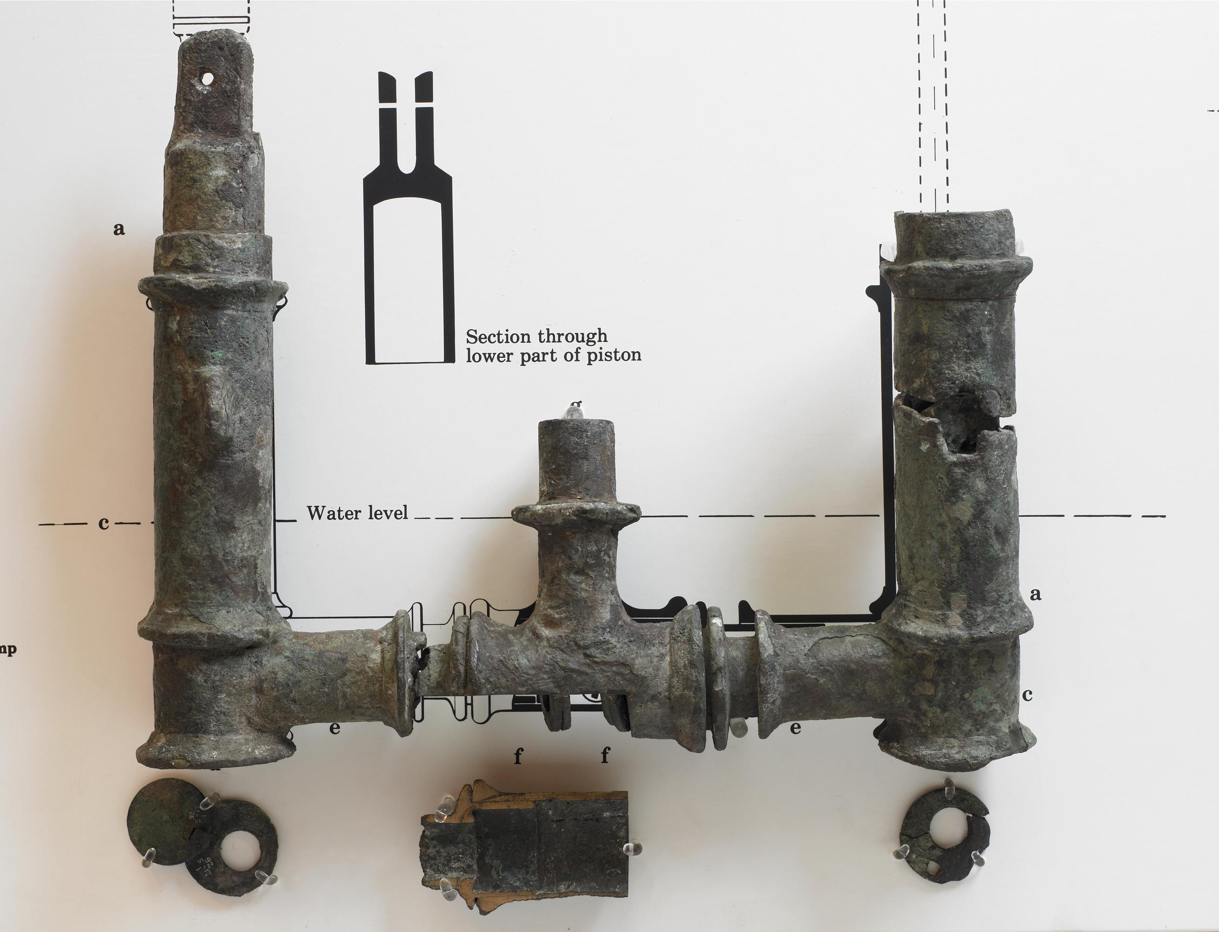 ancient Roman bronze double-action water pump with one barrel and a semicircular bracket, around 3rd century AD. Excavated in Bolsena, Italy. Now housed in the British Museum.jpg