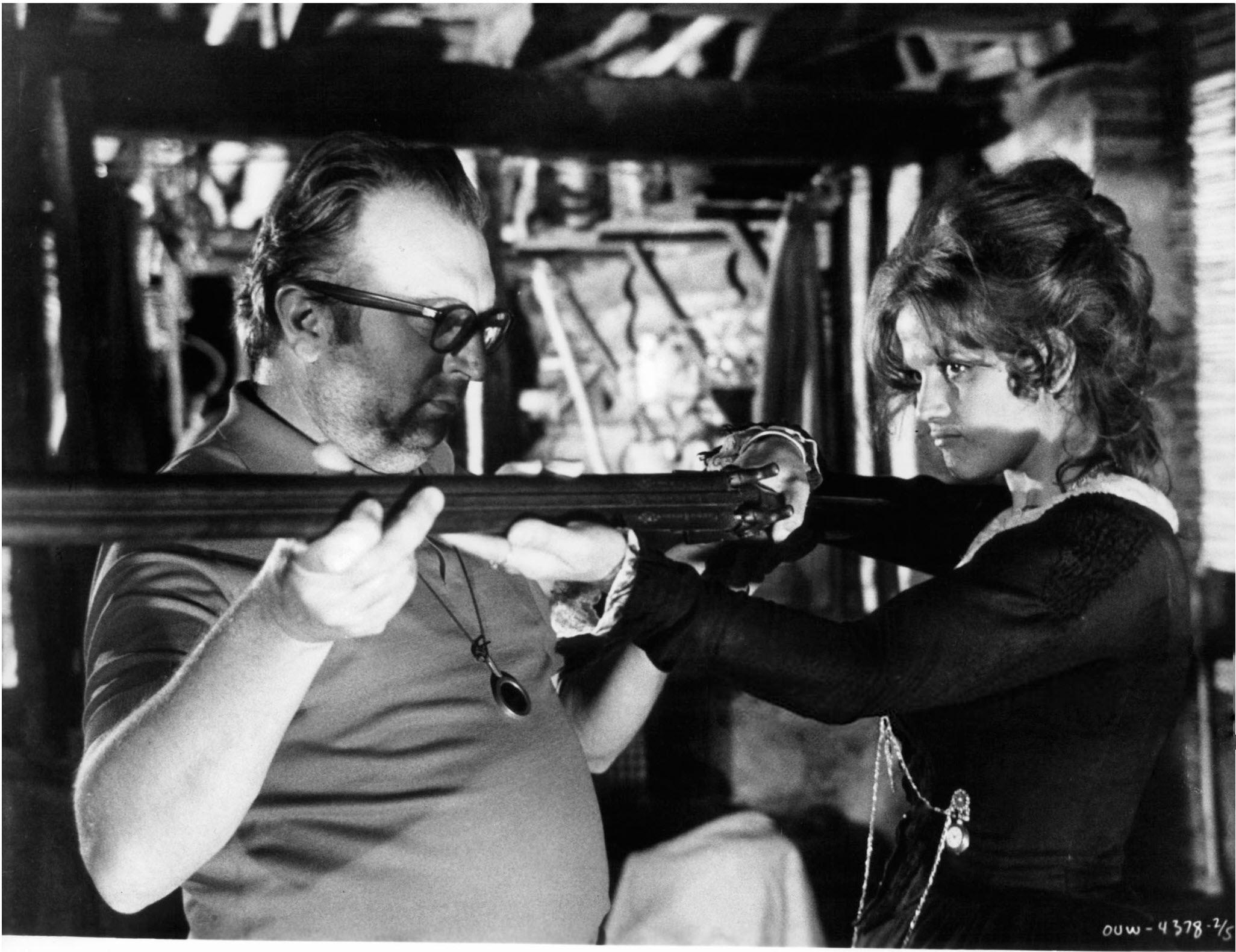 Director of 'Once Upon A Time In The West' Sergio Leone, showing Claudia Cardinale how to aim her rifle, 1968.jpg