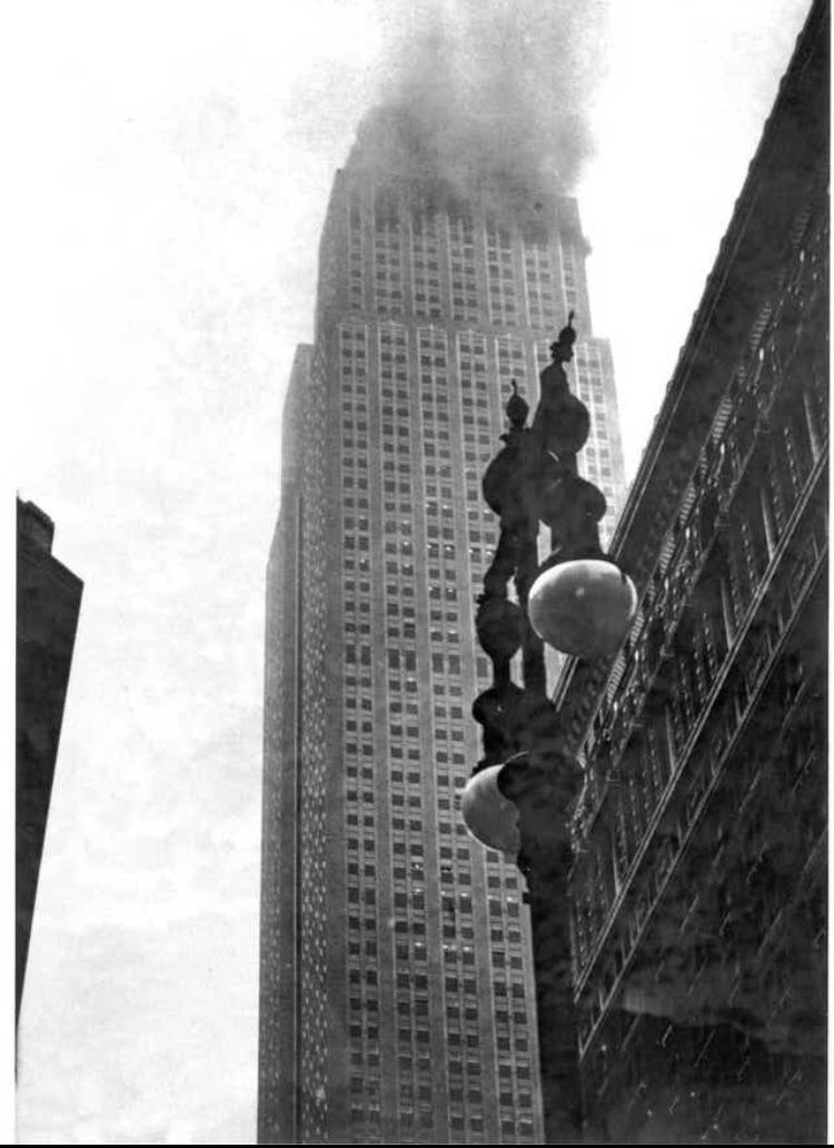 The Empire State Building ablaze after a B-25 bomber crashed into it in thick fog over New York City on July 28, 1945.jpg