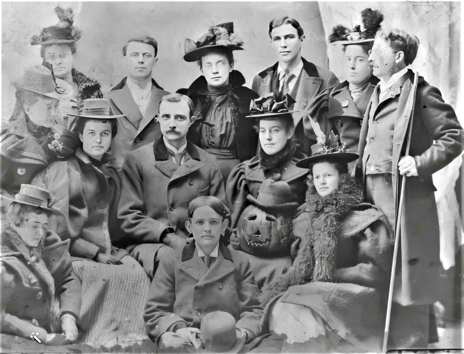 Teachers posing for Halloween with a Jack-o-Lantern wearing a hat, Tioga, PA, 1895.png