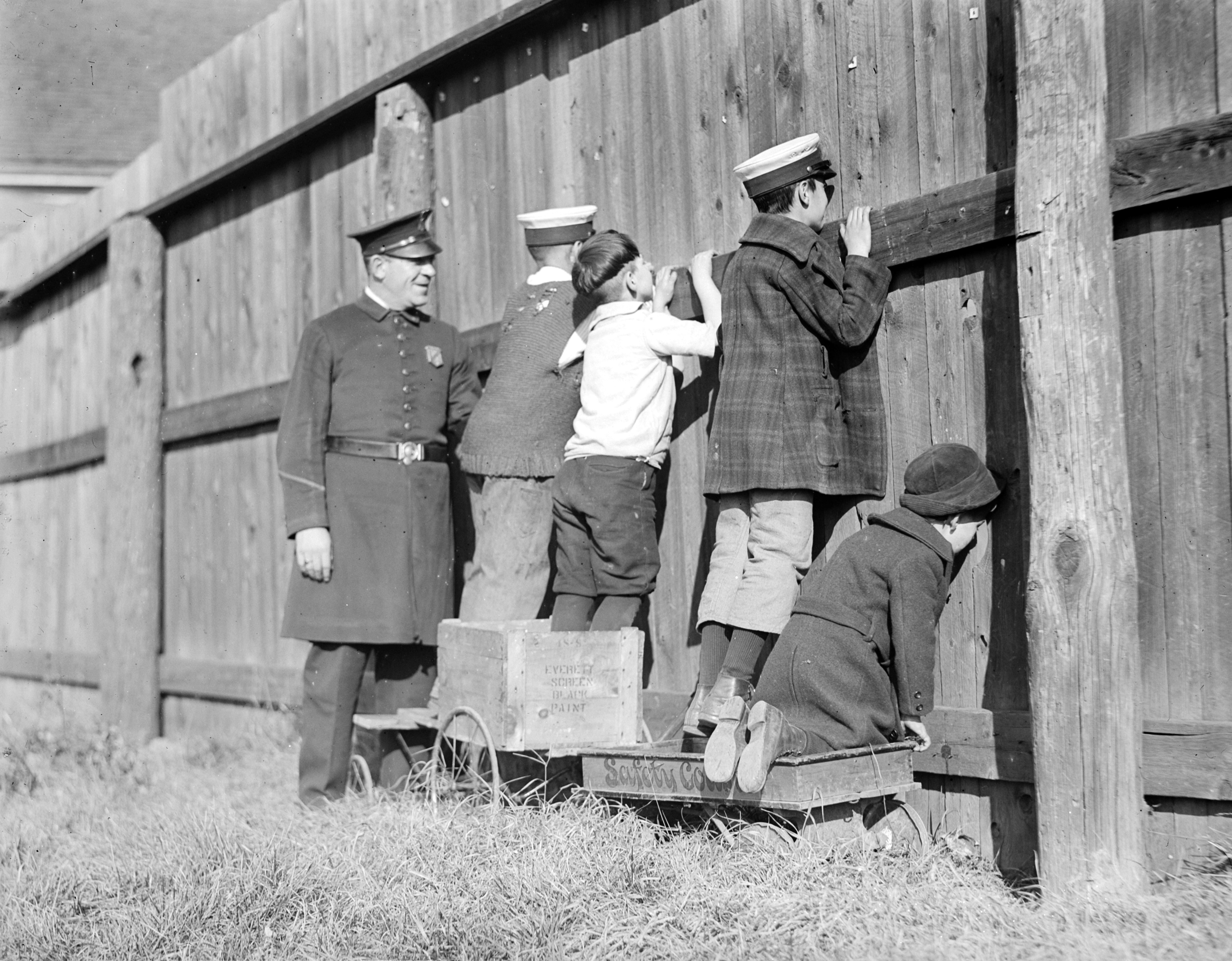 Cop joins baseball peekers at the fence in Massachusetts (c. 1930).jpg