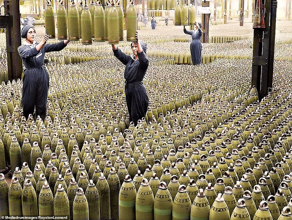 Female munitions workers guide 6-inch howitzer shells being lowered to the floor at the National Shell Filling Factory in Chilwell, Nottinghamshire in July 1917.jpg