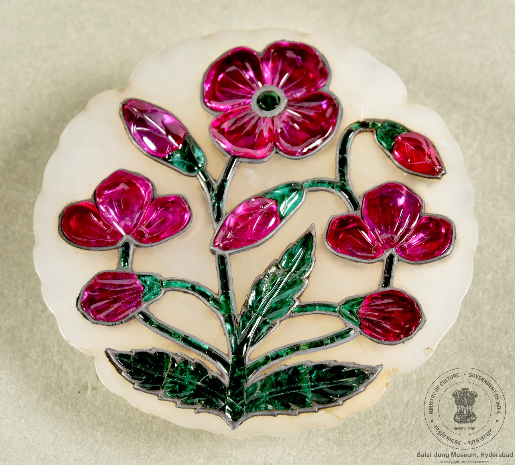 Jade pendent with Rubies and Emeralds set as flower and leaves, 17th century CE. On display at Salar Jung Museum, Hyderabad, India.jpg