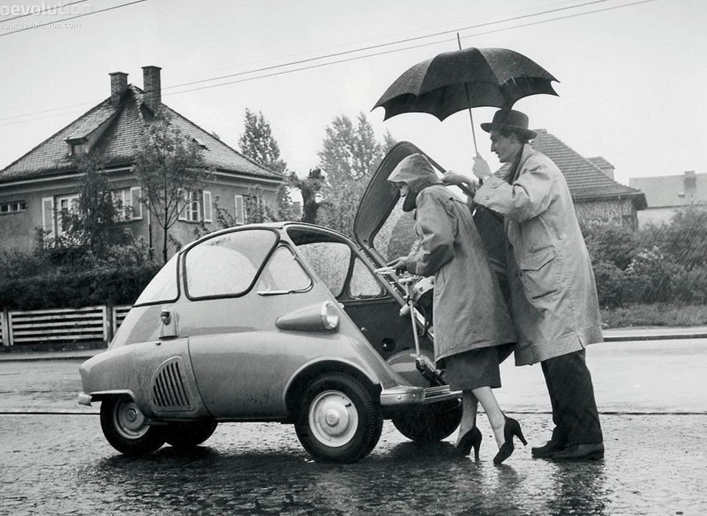 A couple gets into their BMW Isetta through the front door, 1950s.jpg