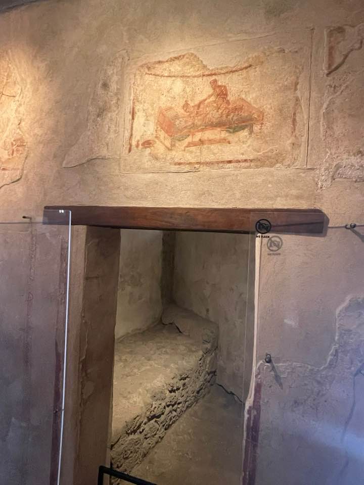 A room in the Lupanar Grande (main brothel) with the specialty of the 'performer' painted above her workplace. Pompeii, Italy.jpg