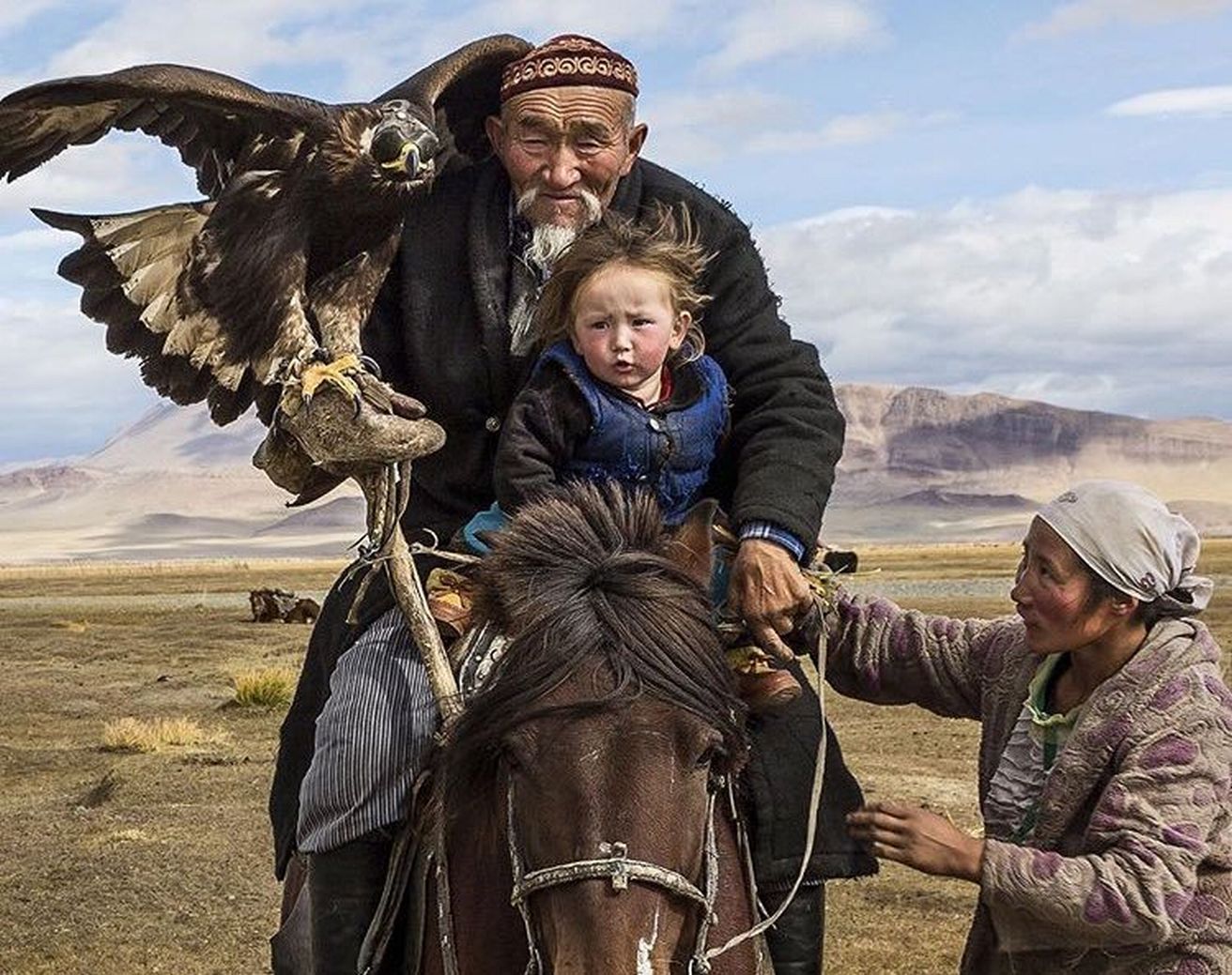 Man taking grandson and an eagle on hunt in the Altai Mountains of Central Asia.jpg