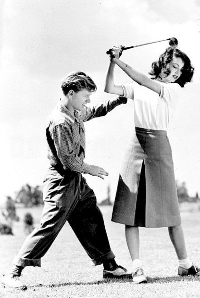 Ava Gardner takes a golfing tip from her husband Mickey Rooney, 29th May 1942.jpg