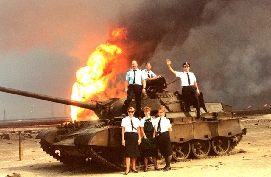 The civilian crew of a Pan Am 747 chartered by the US DoD to transport troops to the middle east for Operation Desert Storm poses with a disabled Iraqi tank and an oil fire. 1990.jpg