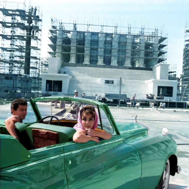 Eddie Fisher and Elizabeth Taylor survey construction of some of the sets of the film Cleopatra, sitting in Taylor's 1960 Rolls Royce, which she called The Green Goddess. 1961.jpg