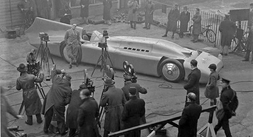 Malcolm Campbell presenting his vehicle called “Bluebird” to journalists in 1935. The car weighed 5 tons and had 2,350 horsepower.jpg